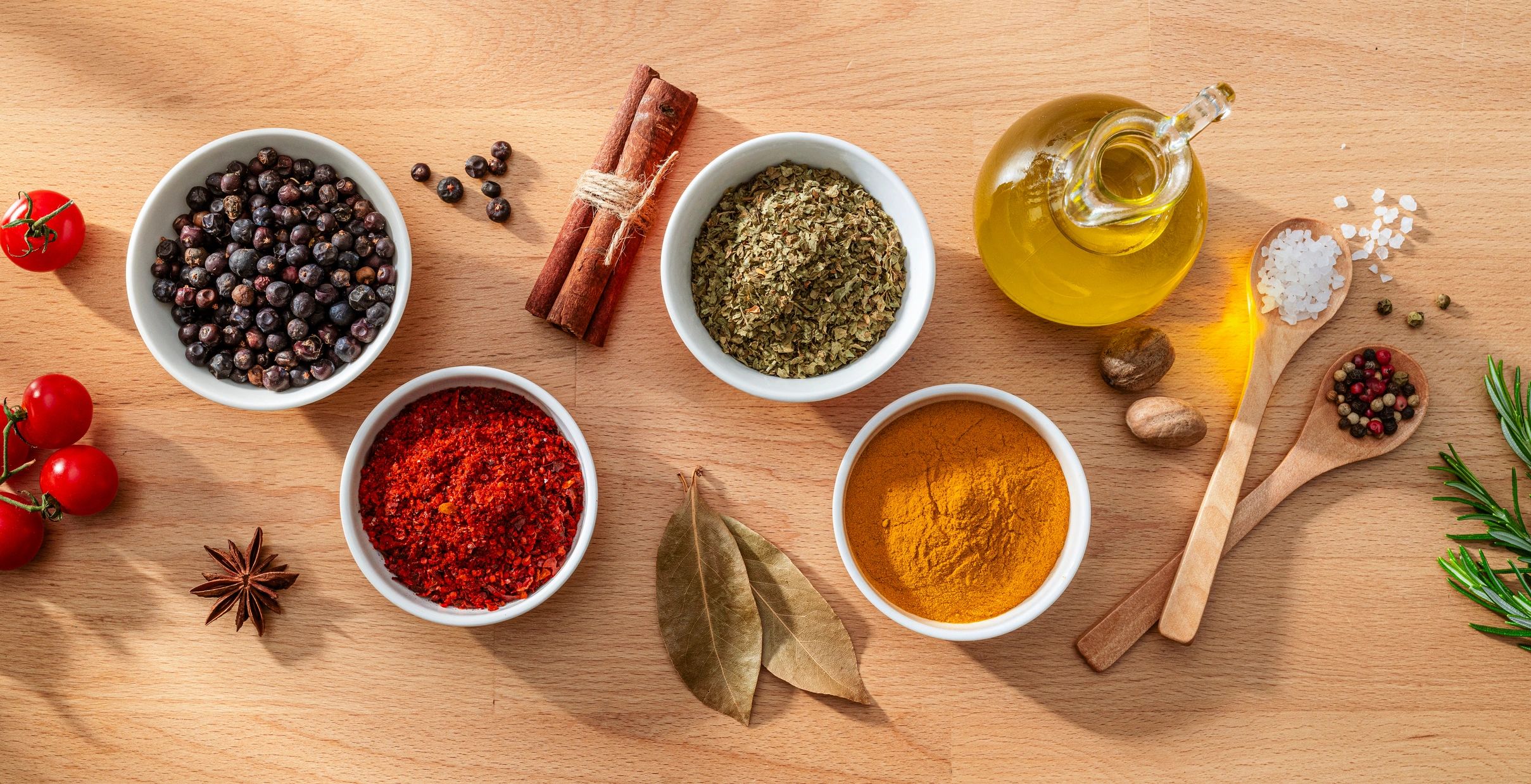 Bowls filled with spices and herbs on a wooden background